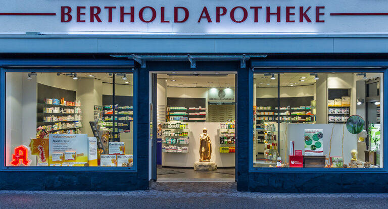 Aussenansicht des beleuchteten Eingangsbereichs der Berthold Apotheke in Villingen